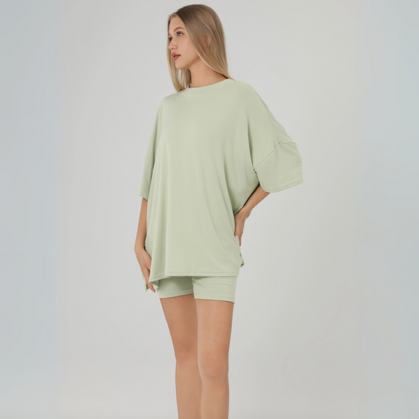Image 1: Woman wearing sage green oversized t-shirt and matching biker shorts