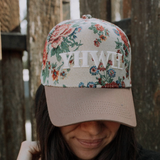 Close-up of YHWH floral embroidered hat with taupe brim and vintage flower print.