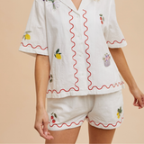 Front view of embroidered lounge shorts with red trim and strawberry details