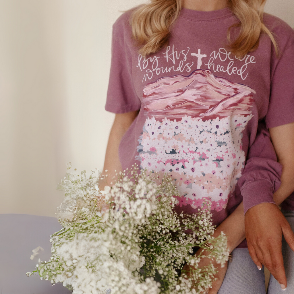 Close-up of mauve Christian graphic tee with floral mountain design