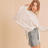 Model in a white button down shirt styled with light denim shorts, front tucked.