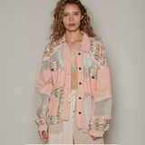 Front view of a floral patchwork mesh jacket with a button-up closure, featuring distressed edges and soft pink tones.