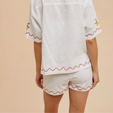 Back view of white shorts with lemon embroidery and scalloped hem