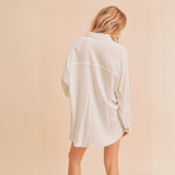 Full front view of oversized white raw hem shirt paired with frayed denim shorts.