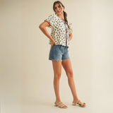 Cream peplum blouse with navy floral print and tie-front closure worn by female model in studio setting.