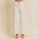Front view of white high-rise wide-leg cotton twill pants with double-button waist and full-length hem, styled with heeled sandals.