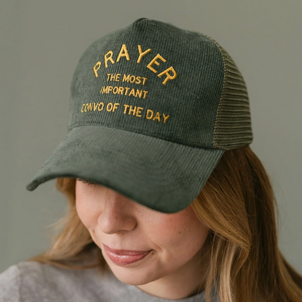 Front view of the "Prayer" snapback hat showcasing the yellow embroidered text on the green cap.