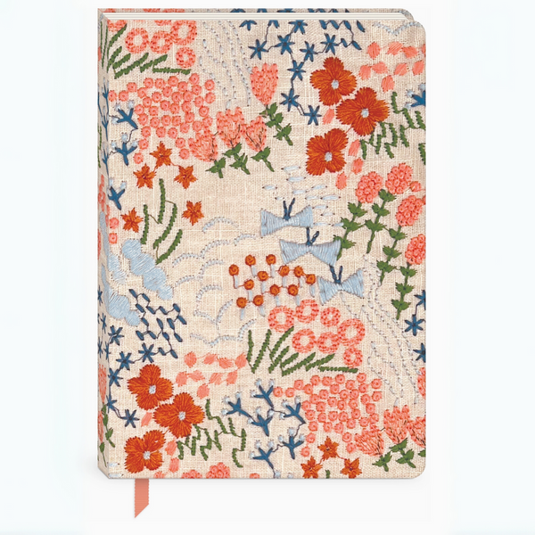 Front view of the Wildflower Meadow Embroidered Fabric Journal featuring a vibrant hand-stitched wildflower design in coral, blue, and green on a natural fabric cover.
