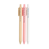 Faith-based pens writing spiritual phrases in ink, laid out on a flat-lay with a notepad.

