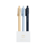 Faith-based pens writing spiritual phrases in ink, laid out on a flat-lay with a notepad.

