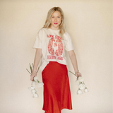 Model holding white flowers while wearing the Cheetah Valentine’s Day Graphic Tee, featuring a hand-drawn cheetah print and soft Comfort Color fabric.