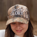 Close-up of "Give God Glory" camo hat being worn, highlighting the white embroidery and camouflage print.