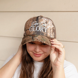 Side view of "Give God Glory" camo hat being adjusted, showcasing its rugged pattern and inspiring message.