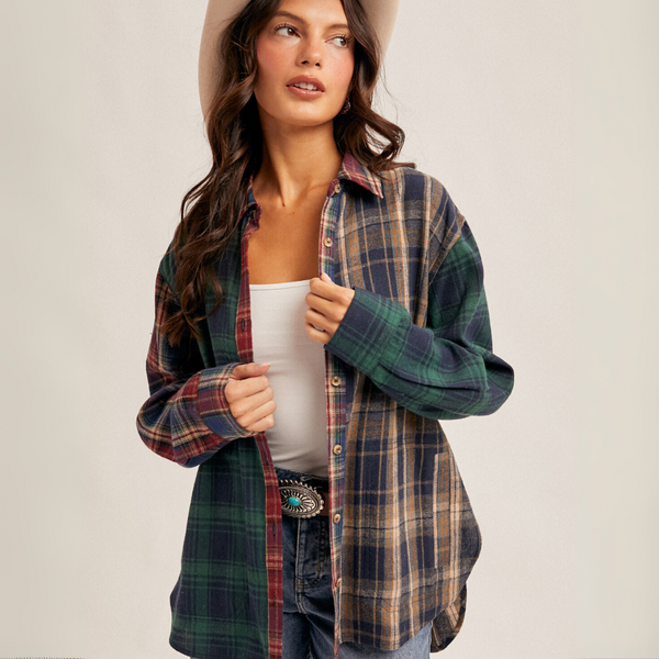 "Front view of woman wearing oversized mixed plaid flannel shirt with red, green, and navy tones"

