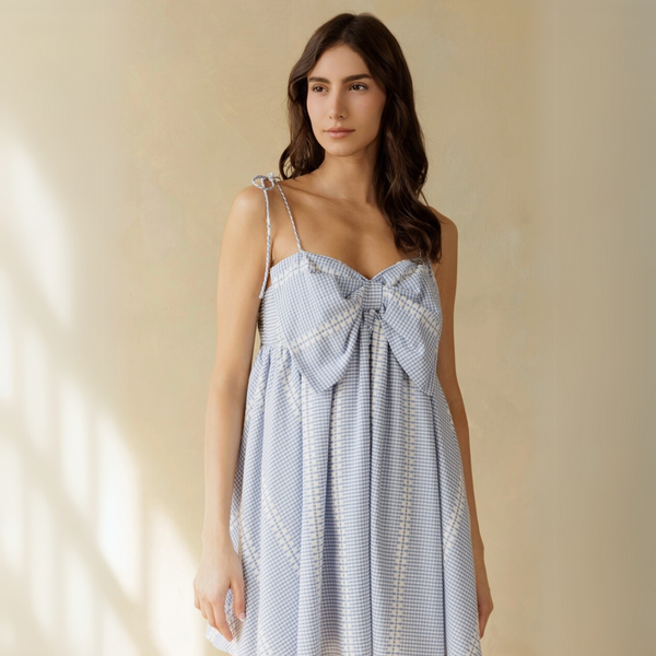  Model wearing sky blue and white puff sleeve mini dress with floral print, front view.

