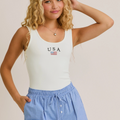 Woman wearing USA ribbed bodysuit with light blue shorts

