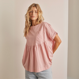 Front view of blush pink peplum cotton top with front pocket and round neckline.
