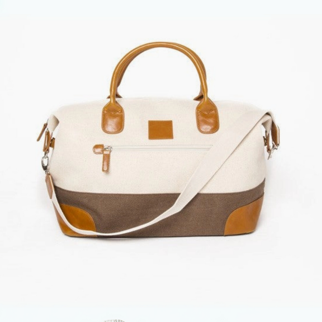 Canvas and leather weekender bag with detachable shoulder strap, leather handles, and front zip pocket—perfect for travel and gym.