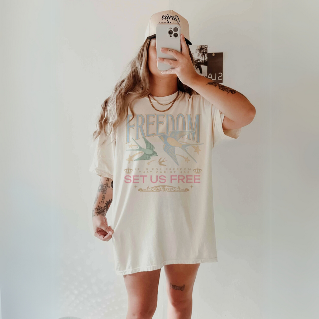 Front view of 'Freedom Set Us Free' oversized graphic tee in ivory.