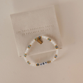 Bracelet with 'JOY' beads on a textured card with engraved text