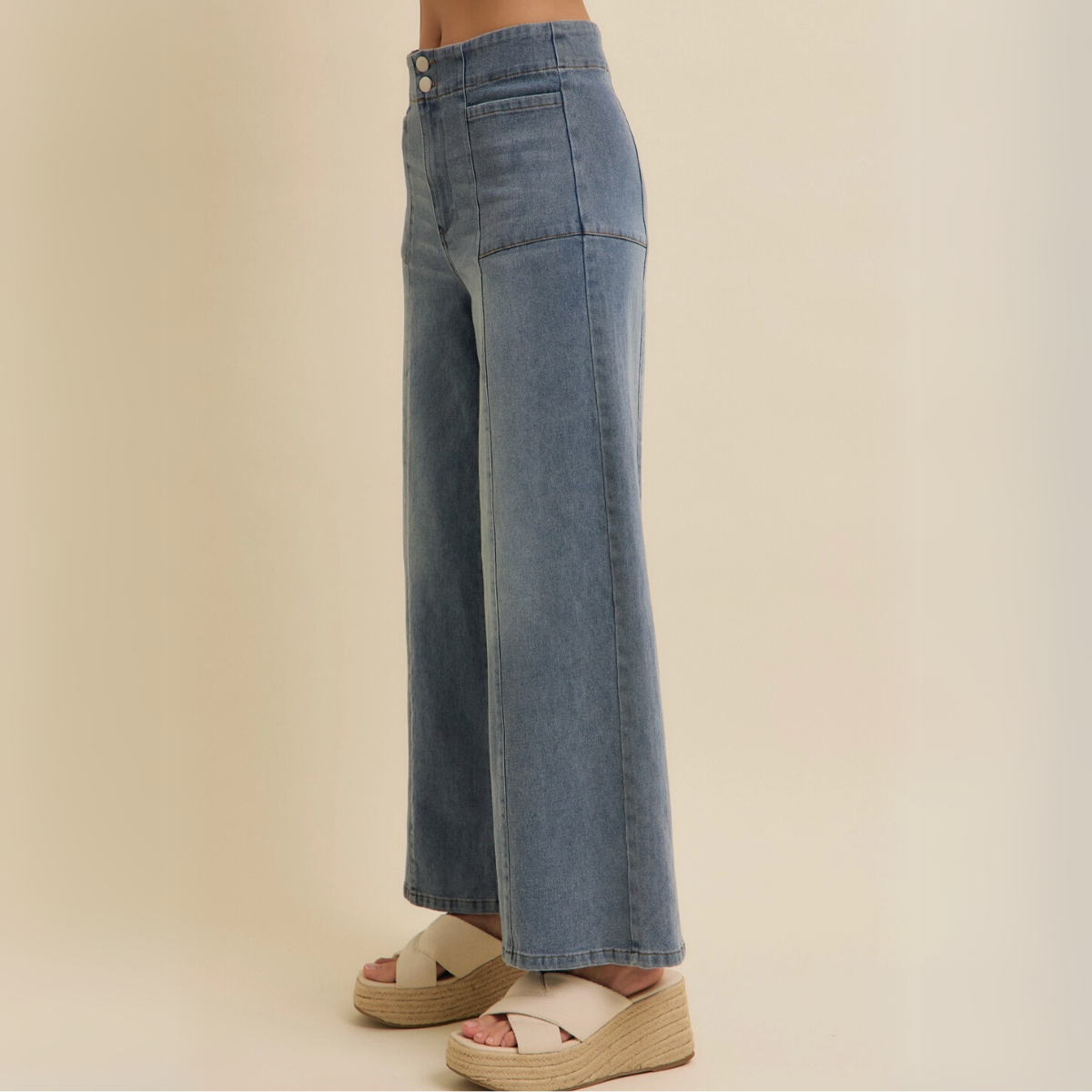 Side view showcasing the wide-leg cut and high-rise waist of denim jeans.
