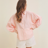 Side profile of the pink striped blouse, showcasing relaxed fit and collar details.
