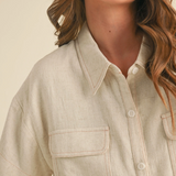 Close-up of natural linen shirt with collar and button detail


