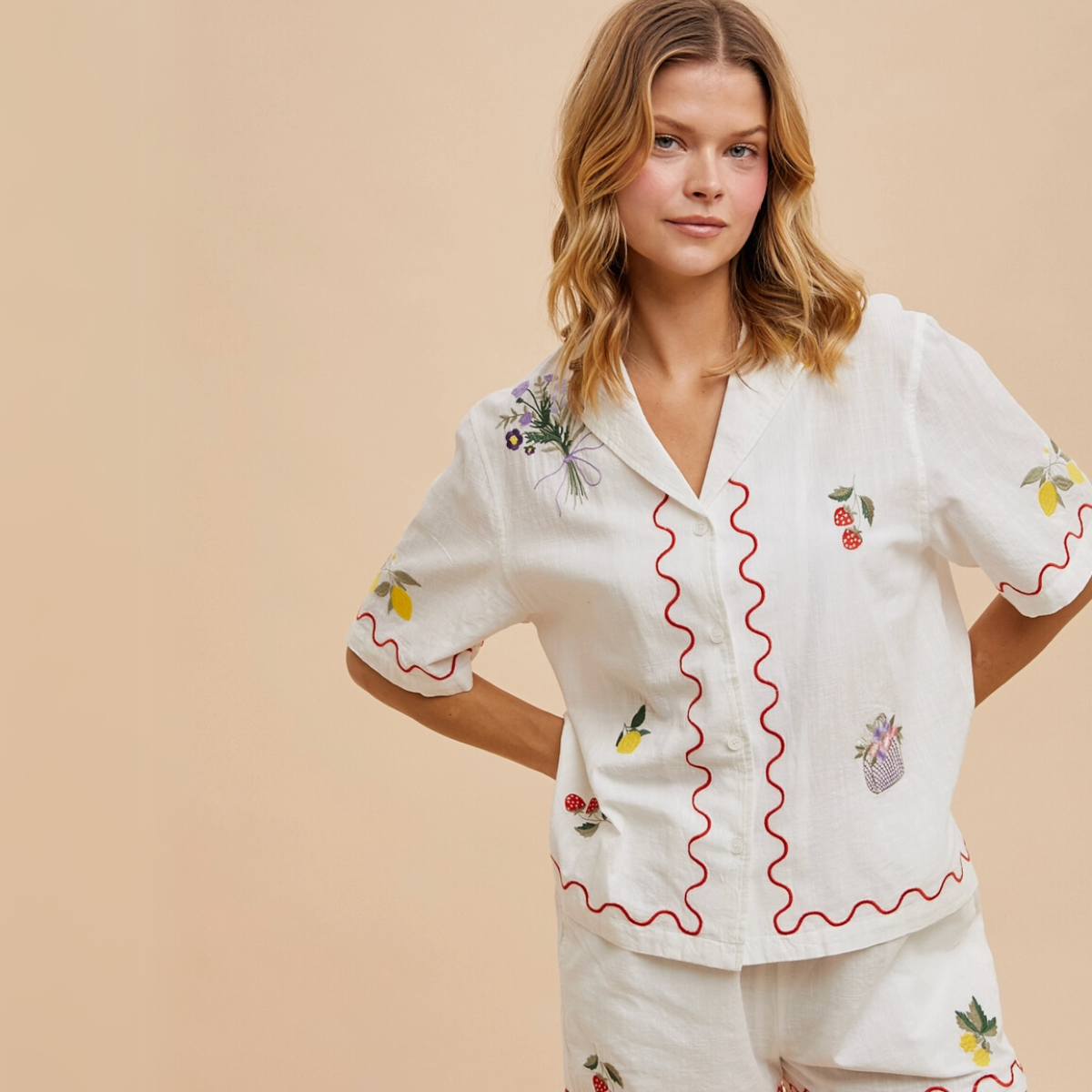 Back view of the embroidered white button-up shirt with red trim.