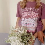 Close-up of mauve Christian graphic tee with floral mountain design