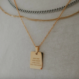 Close-up of gold engraved necklace styled on model.