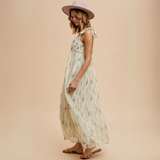Model holding sides of floral tiered maxi dress to show flow

