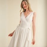 Close-up of V-neck bodice and tie-waist detail on white cotton blend midi dress.