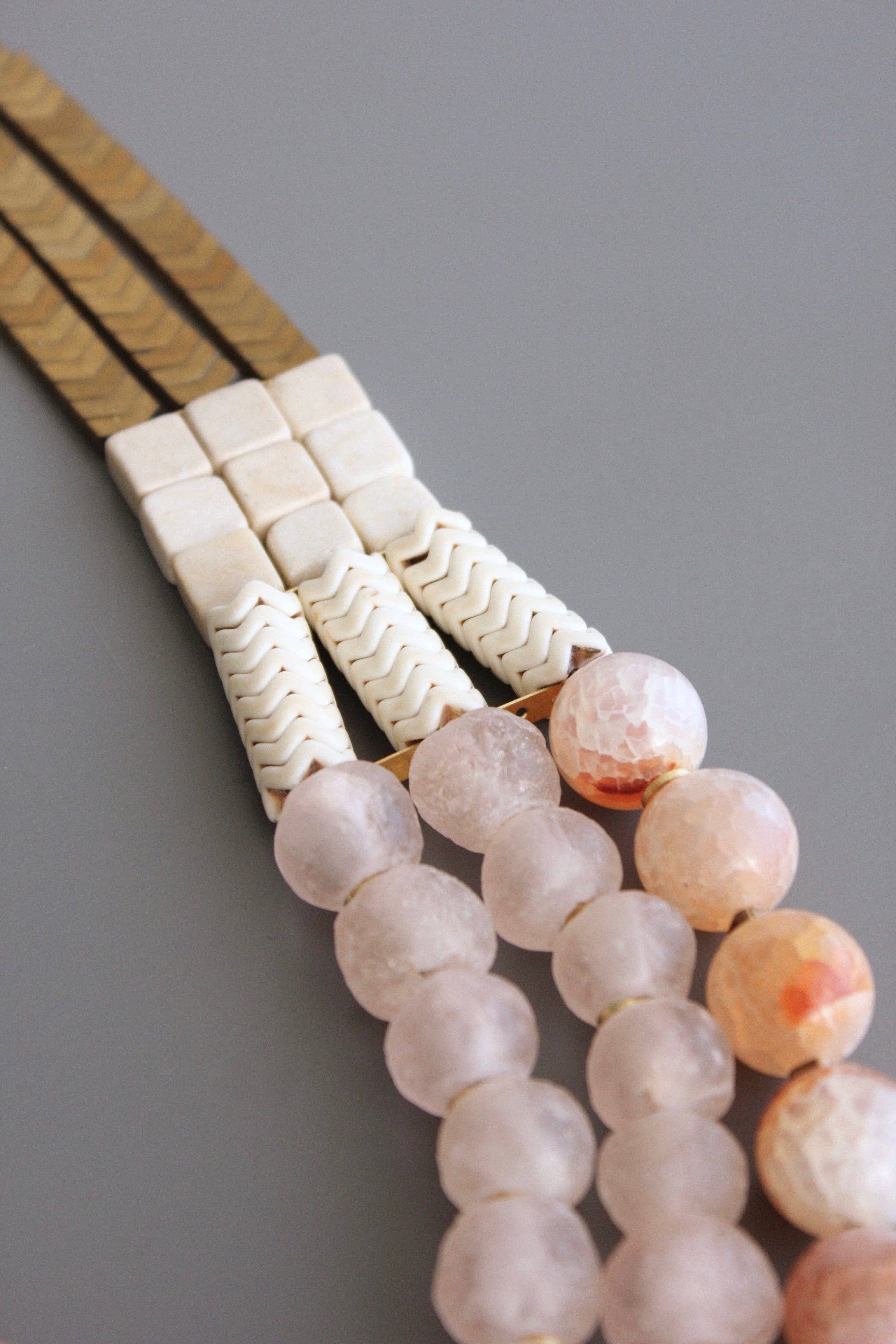 Triple strand necklace with hematite, magnesite, fire agate, glass, and brass