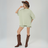 Image 3: Full-body look with cowgirl boots and sage green two-piece set

