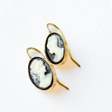  Woman wearing black cameo earrings, showing their elegant design.