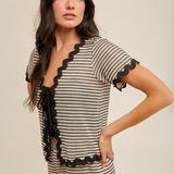 "Back view of crochet knit top with black scalloped trim on sleeves and hem"

