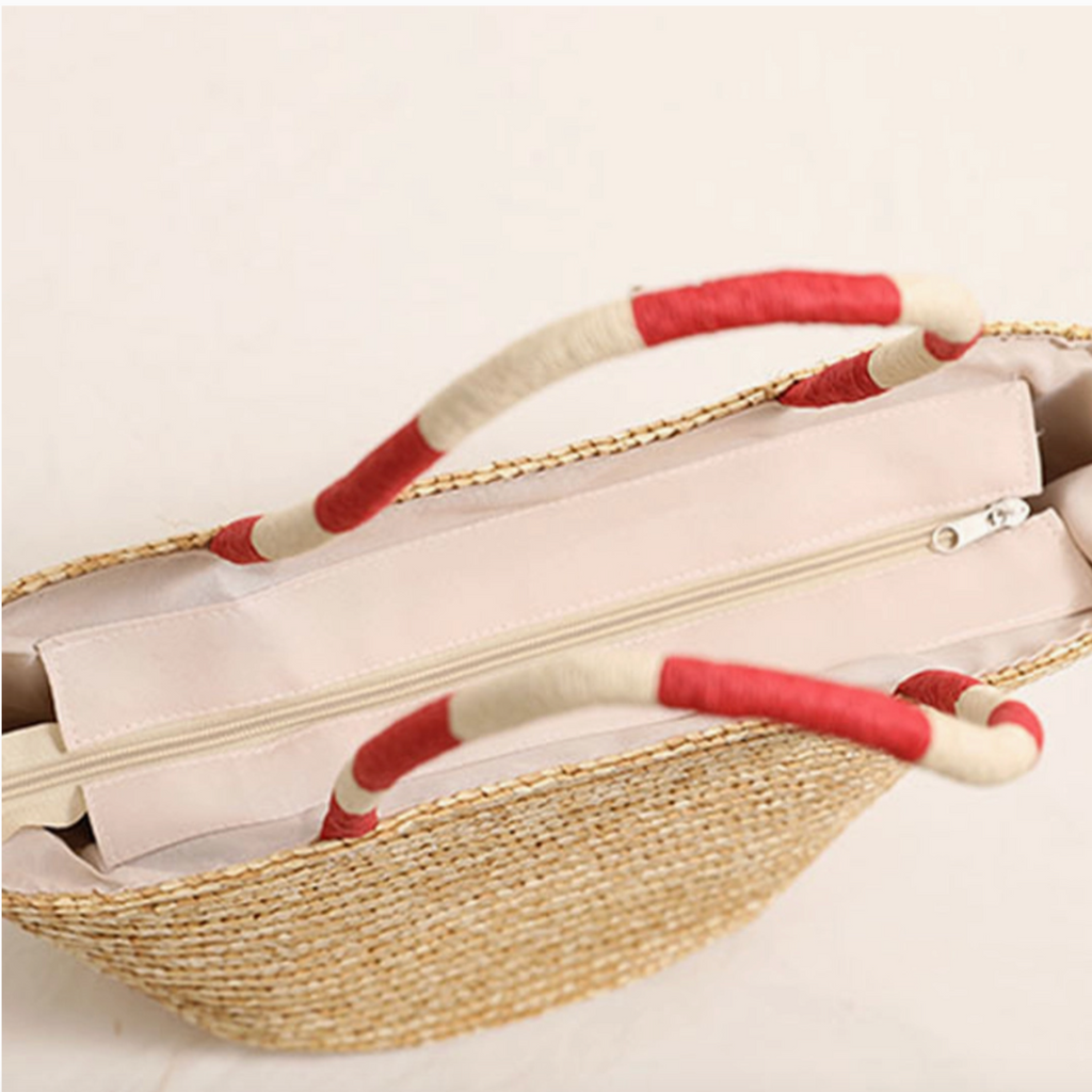 Top view of straw tote bag showing beige fabric lining and zipper closure.

