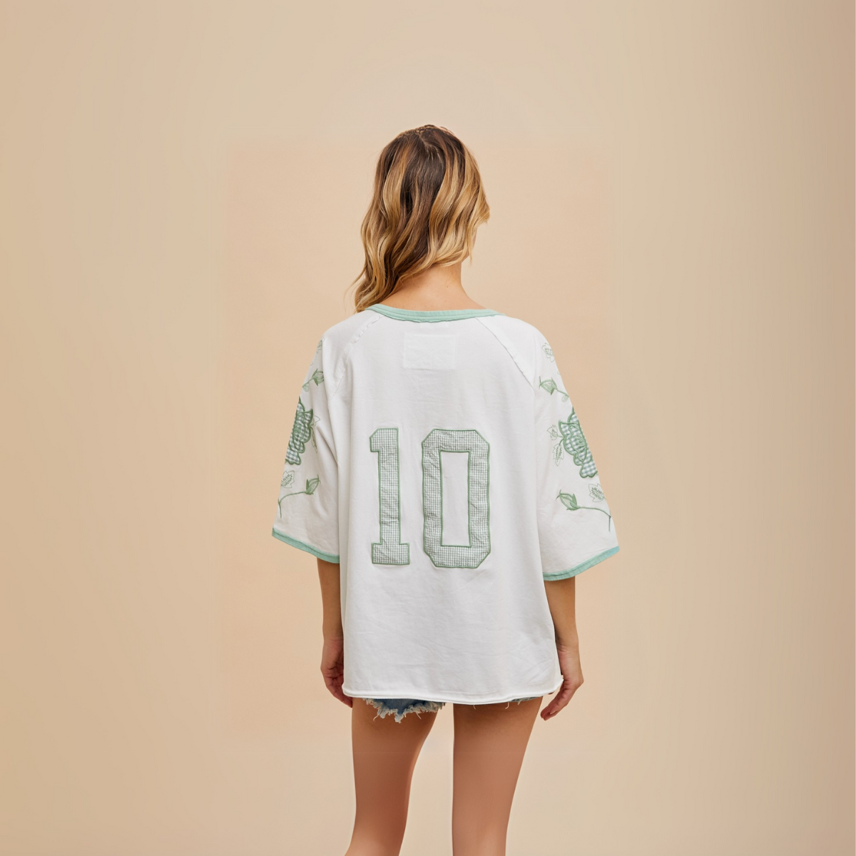 Side profile of embroidered tee showing leafy hop vine graphic on sleeve.

