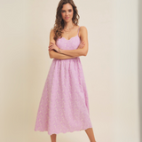 Woman posing in lilac midi dress with arms crossed.