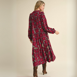 Model wearing floral tiered midi dress with puff sleeves, styled with tall boots.