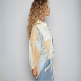 Side view of model in patchwork kimono-style top with gathered sleeves and paisley details.