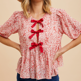 Close-up of Bow Accent Floral Top's red ribbon ties and delicate crinkle floral texture.