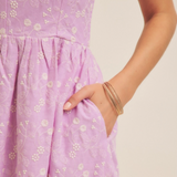 Close-up of hidden pocket detail on lilac dress.