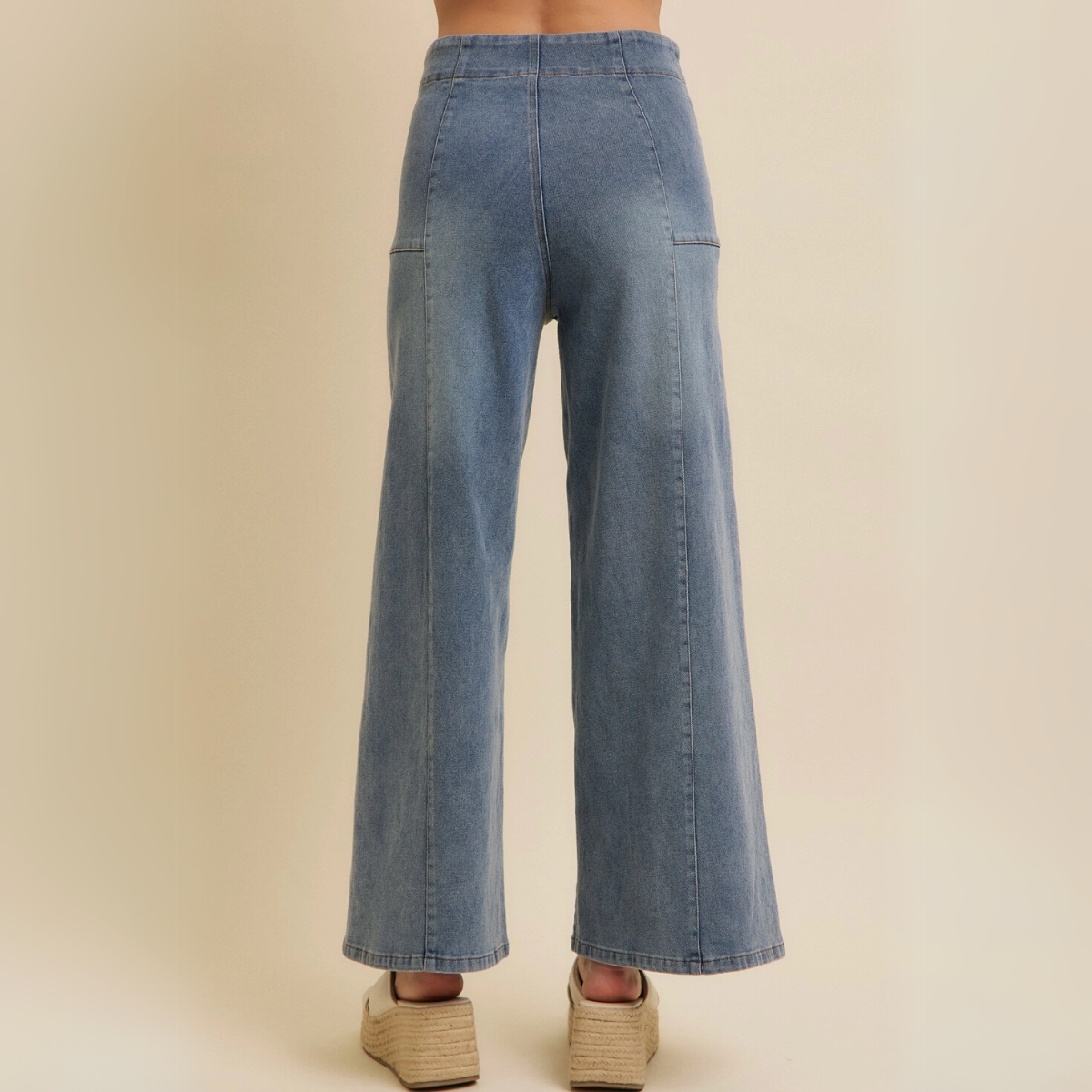 Back view of wide-leg denim jeans showing rear seam details and high waist.
