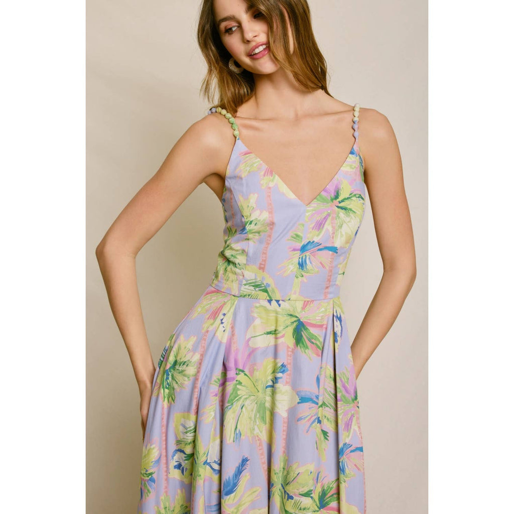 Woman wearing a colorful floral dress against a neutral background