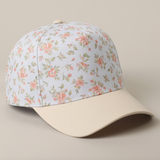 Angled view of cream and pink floral baseball cap with beige brim
