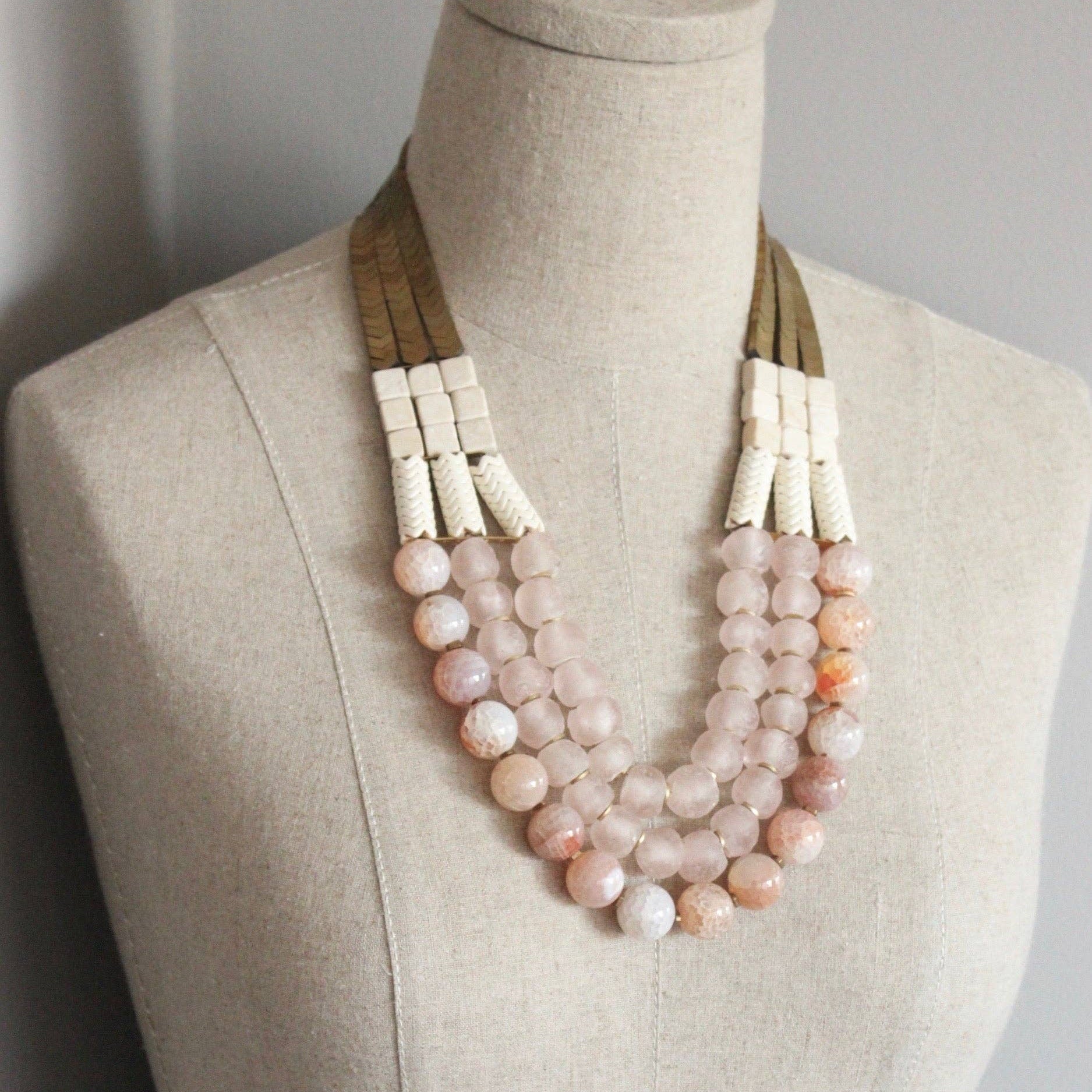 Triple strand necklace with hematite, magnesite, fire agate, glass, and brass