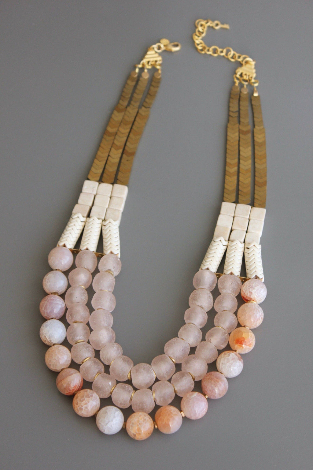 Triple strand necklace with hematite, magnesite, fire agate, glass, and brass