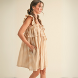 Side view highlighting adjustable spaghetti straps and side slit of En Merci caramel stripe midi dress.