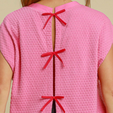 Close-up of Bubble Pink Dolman Top showing three red bow details on the back.